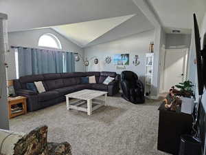 Carpeted living room with vaulted ceiling