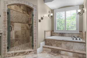 Full bathroom featuring a bath, a shower stall, and vaulted ceiling