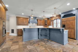 Kitchen with premium range hood, built in appliances, recessed lighting, a breakfast bar area, and baseboards