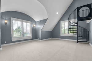 Additional living space featuring lofted ceiling, baseboards, carpet floors, and stairs