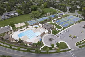 Drone / aerial view of community pool and pickleball courts