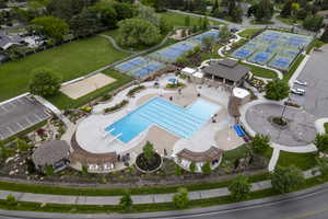 Drone / aerial view of community pool and pickleball courts