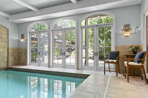 View of indoor swimming pool with french doors