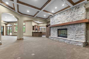 Living room featuring light carpet, a fireplace, coffered ceiling, beam ceiling, and recessed lighting