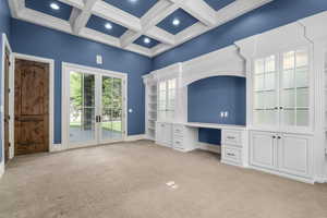 Room with access to exterior, french doors, light colored carpet, beamed ceiling, and coffered ceiling
