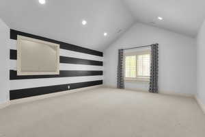 Spare room featuring vaulted ceiling, recessed lighting, carpet, and baseboards