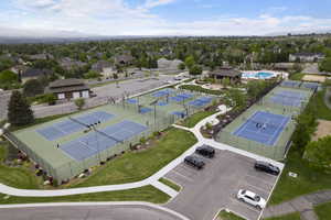 Drone / aerial view of community pool and pickleball courts with valley view