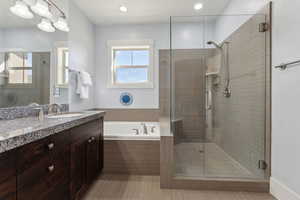 Full bath featuring a shower stall and vanity