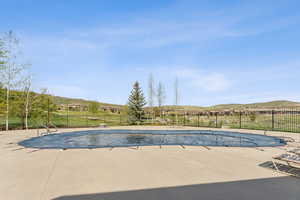 View of pool with fence, a patio, and a mountain view