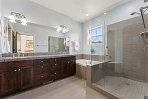Bathroom featuring a stall shower, a bath, and double vanity