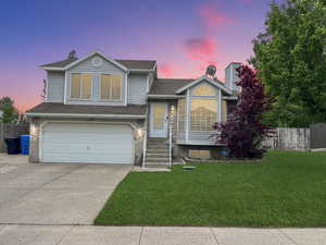 Tasteful exterior of home featuring a 2 car garage and beautiful landscape and mature trees