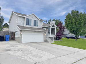 Tasteful exterior of home featuring a 2 car garage and beautiful landscape and mature trees, and RV parking next to the driveway
