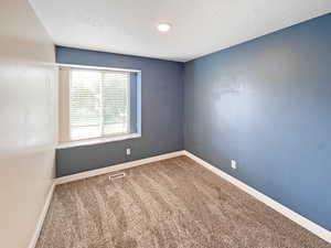 Bedroom 3 upstairs with a view of the front of the house and boasting cozy new carpet