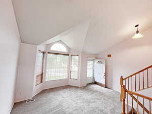 Entry into the home, featuring the living room and beautiful vaulted ceilings and ample natural light