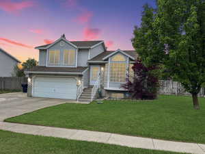 Tasteful exterior of home featuring a 2 car garage and beautiful landscape and mature trees