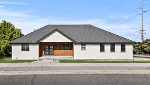 View of front of home featuring roof with shingles, a porch, french doors, and stucco siding