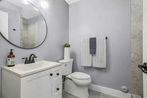 Full bath with wood finished floors, vanity, and a tile shower