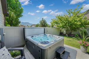 Fenced backyard with a hot tub and a mountain view