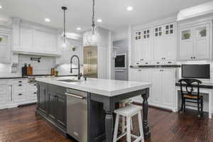 Kitchen with white cabinetry, dark wood-style flooring, tasteful backsplash, stainless steel appliances, and recessed lighting