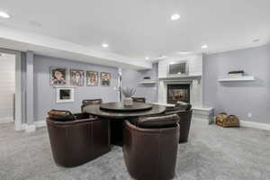Living area featuring carpet, a fireplace, and recessed lighting