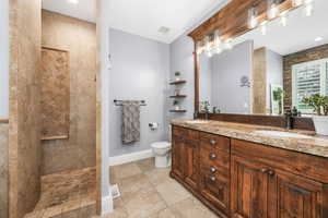 Full bath featuring double vanity, a walk in shower, and tile patterned flooring