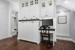 Kitchen featuring dark countertops, white cabinets, dark wood-style flooring, and glass insert cabinets