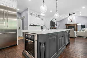 Kitchen with appliances with stainless steel finishes, white cabinets, dark wood-style floors, gray cabinetry, and recessed lighting