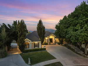 View of front of house featuring driveway, a gate, stucco siding, and a tiled roof