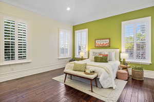 Bedroom featuring ornamental molding, multiple windows, hardwood / wood-style flooring, baseboards, and recessed lighting