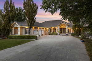 Single story home featuring a garage, driveway, and a front lawn