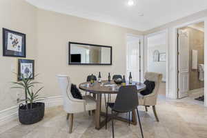 Dining room with ornamental molding and baseboards