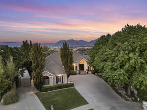 View of front facade featuring driveway, a tiled roof, a gate, stucco siding, and a mountain view