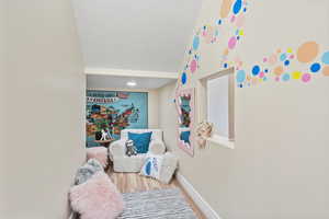 Game room with wood finished floors, baseboards, and vaulted ceiling