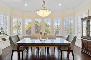 Dining room featuring recessed lighting, dark wood-type flooring, baseboards, and crown molding