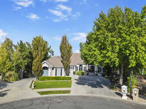 View of front of house with driveway, a tiled roof, and a gate