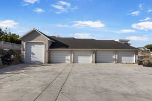 Ranch-style house featuring concrete driveway, a garage, a shingled roof, and fence