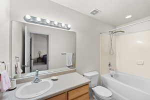 Bathroom featuring vanity, toilet, and washtub / shower combination