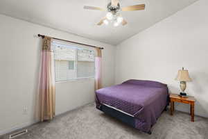 Bedroom featuring carpet flooring, baseboards, vaulted ceiling, and a ceiling fan