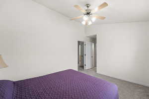 Bedroom featuring light colored carpet, baseboards, and a ceiling fan