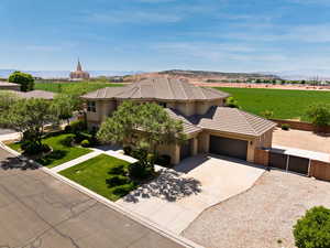 View of front of home with a garage, concrete driveway, stucco siding, a gate, and a tiled roof