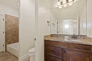 Bathroom with toilet, vanity, tile patterned floors, and baseboards