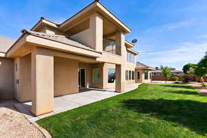 Rear view of property with stucco siding, a balcony, a patio, and a tile roof