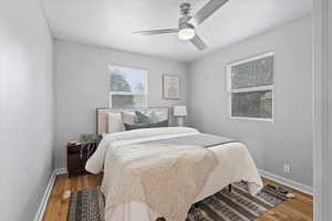 Bedroom featuring baseboards, wood finished floors, and ceiling fan
