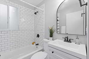 Bathroom featuring toilet, washtub / shower combination, and vanity
