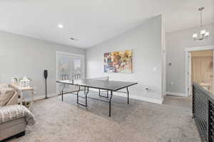 ADU second floor rec room/living room with vaulted ceilings, light colored carpet, recessed lighting and two-tone paint