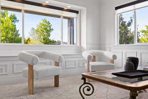 Front sitting room with large windows, wainscot walls, and light carpet