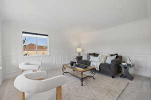 Front sitting room with large windows, wainscot walls, and light carpet