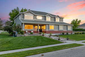 View of front of home with a spacious porch, mixed brick and stucco exterior