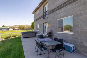 View of ADU patio with a hot tub, grilling area, outdoor dining area, and a mountain view