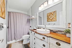 ADU Full bathroom with toilet, vanity, and shower / bath combo with shower curtain